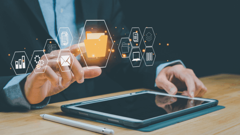 Fotografia di un professionista al lavoro su un tablet, dal quale emerge un'interfaccia olografica con al centro una grande cartella circondata da icone di documenti e dati